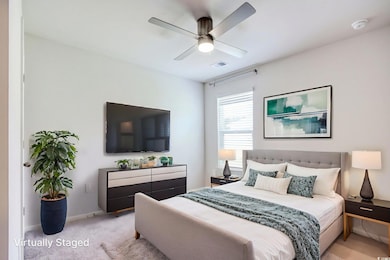 Carpeted bedroom featuring a ceiling fan and baseboards