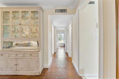 Hallway featuring crown molding and wood-type floo
