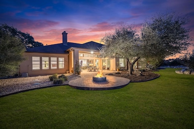 Back of property featuring a fire pit, a lawn, st