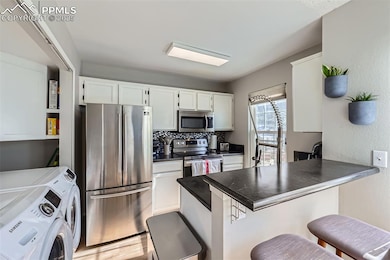 Kitchen with white cabinetry, a breakfast bar area