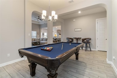 Recreation room featuring arched walkways, billiards table, wood tiled floors, recessed lighting, and a ceiling fan