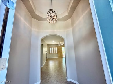 Corridor with arched walkways, baseboards, and a c