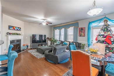 Living room featuring a tiled fireplace, ceiling f