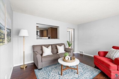 Living room with a textured ceiling and dark wood-type flooring