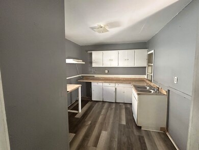 Kitchen featuring white cabinets, dark wood-type flooring, and light countertops