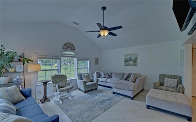 Living room featuring light tile patterned floors, a ceiling fan, high vaulted ceiling, and baseboards
