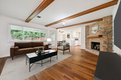 Living room with wood beamed ceilings and fireplac