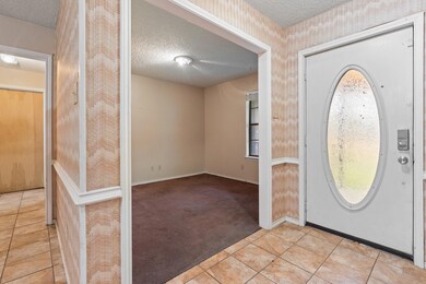 Carpeted entryway with a textured ceiling