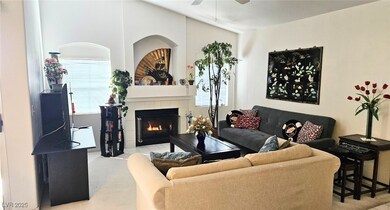 Living area with a ceiling fan, a tile fireplace,