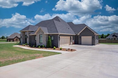 View of front of property featuring a garage, concrete driveway, roof with shingles, and brick siding