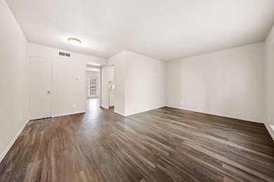 Empty room featuring dark wood-type flooring, bas