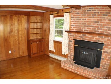 Den area. Hardwood flooring. Wood paneling. Built-