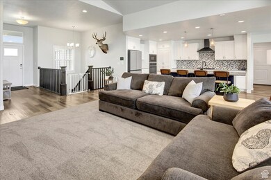 Living room featuring recessed lighting, light wood-style floors, a chandelier, and light colored carpet
