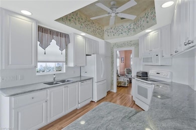 Kitchen featuring white appliances, white cabinetr