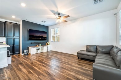 Living area featuring dark wood-style floors, ceiling fan, and recessed lighting