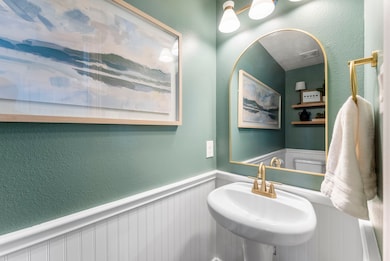 The powder room, conveniently located on the first floor,  features beautiful gold hardware and a matching mirror