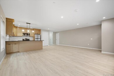 Kitchen Open To Dining Area with Peninsula & Pendant Lighting, Luxury Vinyl Plank Floors, Stainless Steel Appliances, Granite Countertops & Tile Backsplash