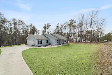 Ranch-style house featuring a garage and a front y