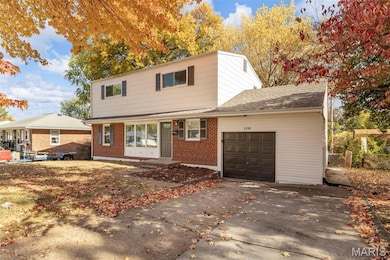 View of front of home featuring an attached garage, a shingled roof, brick siding, and driveway