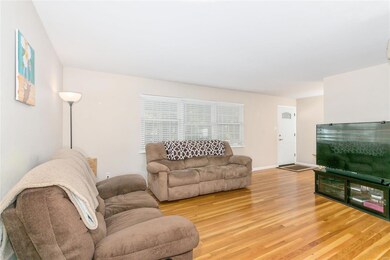 Large living room with neutral paint, faux blinds,