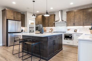 Kitchen featuring decorative light fixtures, decorative backsplash, dark brown cabinetry, stainless steel appliances, and recessed lighting