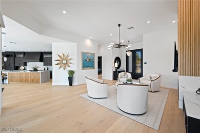 Living room with a notable chandelier, light wood-