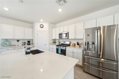 Kitchen featuring stainless steel appliances, white cabinets, and white quartz counters