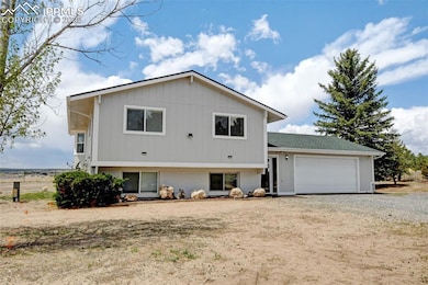 Rear view of house with brick siding, a garage, and driveway