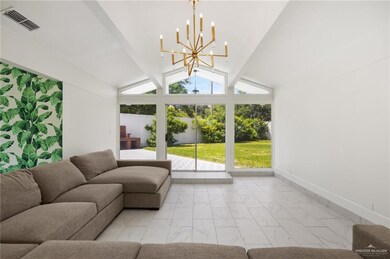 Tiled living room with an inviting chandelier, beam ceiling, and high vaulted ceiling