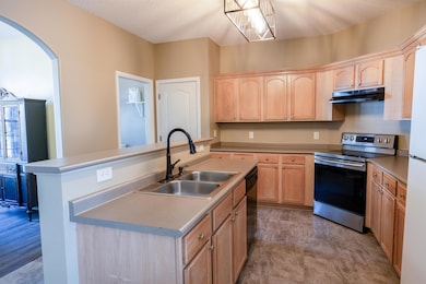 Kitchen featuring light brown cabinetry, stainless