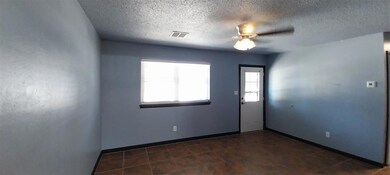 Spare room with a textured ceiling, ceiling fan, a
