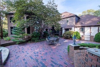 Outside, a sanctuary of gardens w many all-brick patios, a built-in Ducane Natural Gas Grill, a gazebo & accented by exterior lighting.