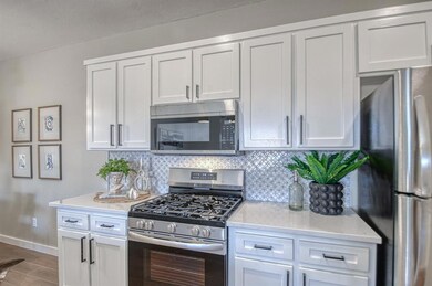 Kitchen with stainless steel appliances, backsplas