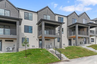 View of front facade with stucco siding, a front yard, and a balcony