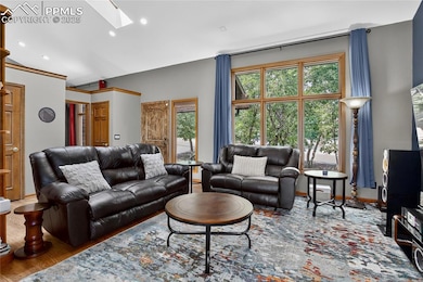 Living area with a skylight, wood finished floors, and recessed lighting