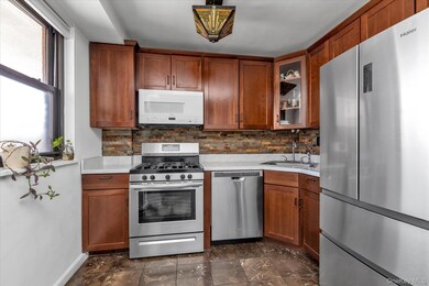 Kitchen with appliances with stainless steel finishes, backsplash, light countertops, and brown cabinetry