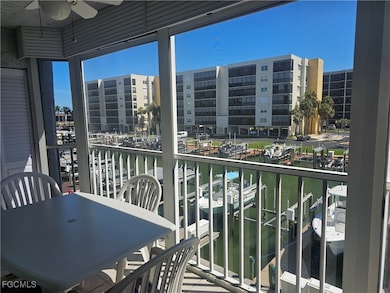Balcony featuring a water view, a ceiling fan, view of marina, and a sunroom