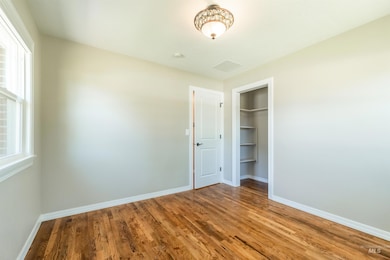 Bedroom with wood finished floors and a closet