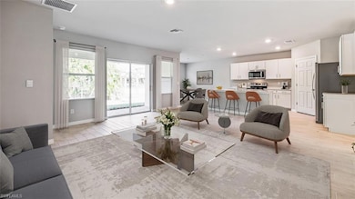Living area with healthy amount of natural light, recessed lighting, light wood-style flooring, and baseboards