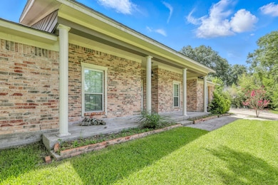 Covered front porch with classic columns and brick