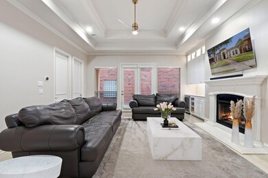 Living room featuring a raised ceiling, ceiling fa