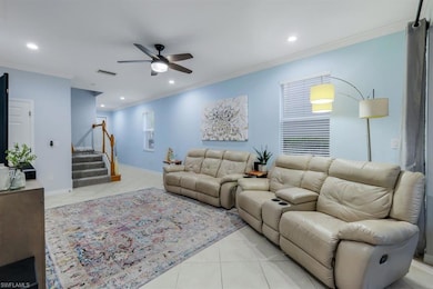 Living room featuring crown molding, ceiling fan, 