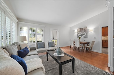 Living area featuring wood finished floors and vaulted ceiling