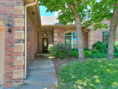 View of exterior entry with brick siding and a shingled roof