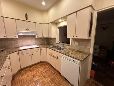 Kitchen featuring white cabinets, backsplash, whit