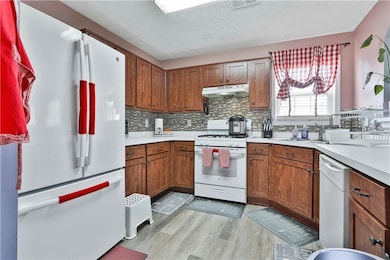 Kitchen with tasteful backsplash, light wood-type 