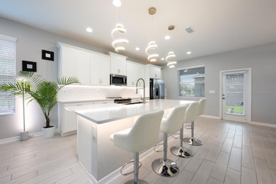 The gorgeous kitchen has access to your covered paver lanai, and the 2-car garage beyond!