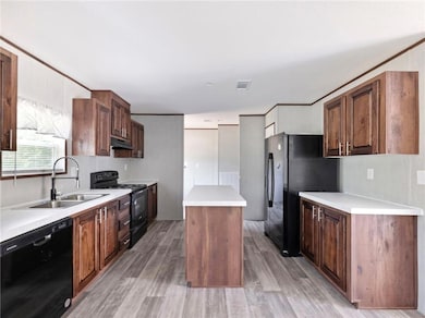 Kitchen with black appliances, a sink, a center is