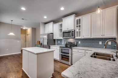 Kitchen featuring white cabinetry, sink, a center 