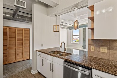 Kitchen with white cabinets, sink, hanging light f